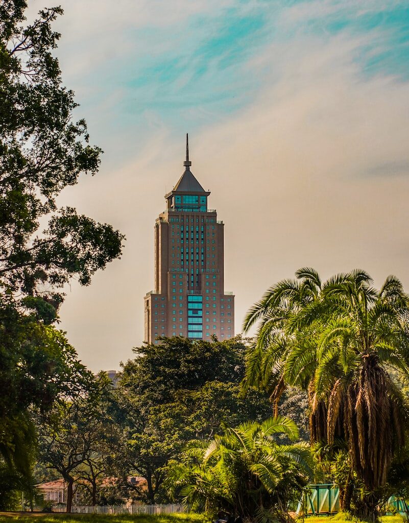 brown concrete building near green trees under blue sky during daytime